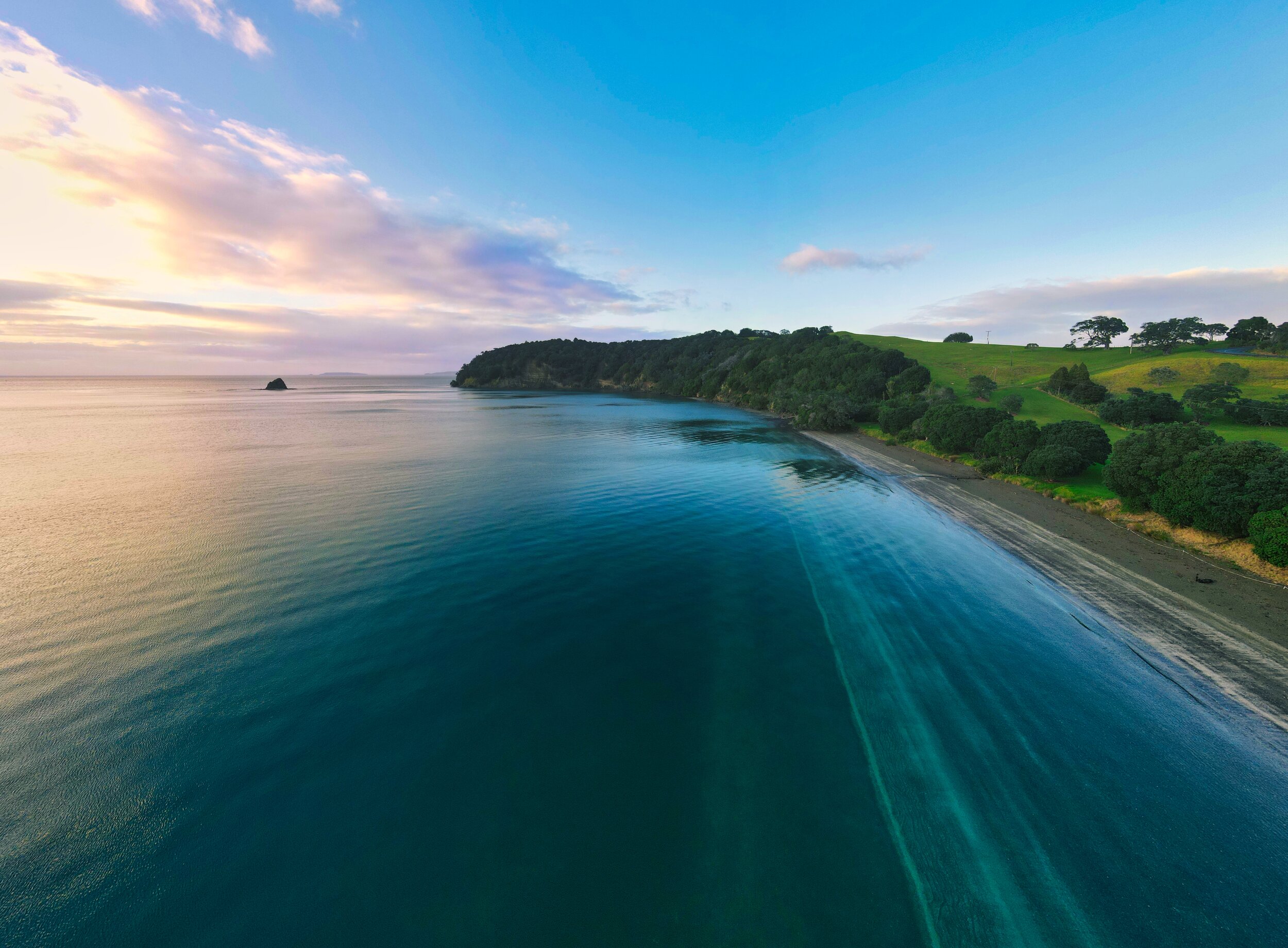 Aerial view of a New Zealand coastal bay at dusk